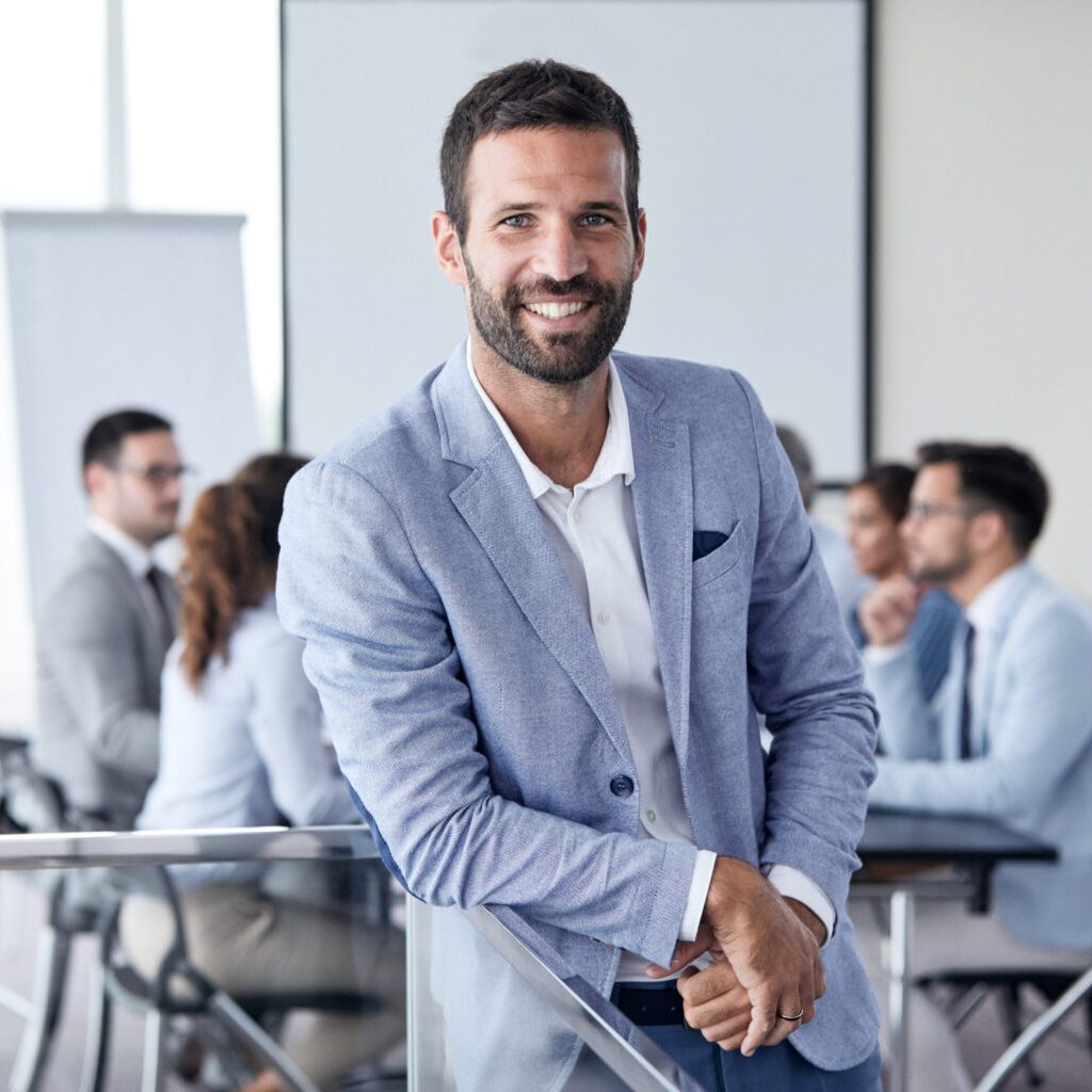 A portrait of a young smiling businessman  a meeting and presentation in the office. Business concept
